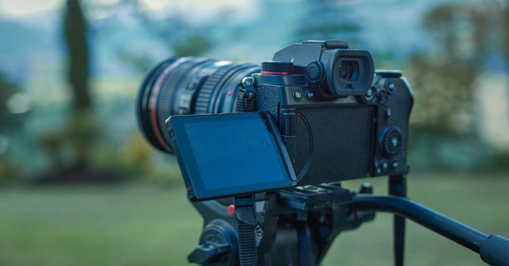 A video camera on a tripod stands amidst morning mist, patiently awaiting the sunrise, poised to capture the magical moments of a new day